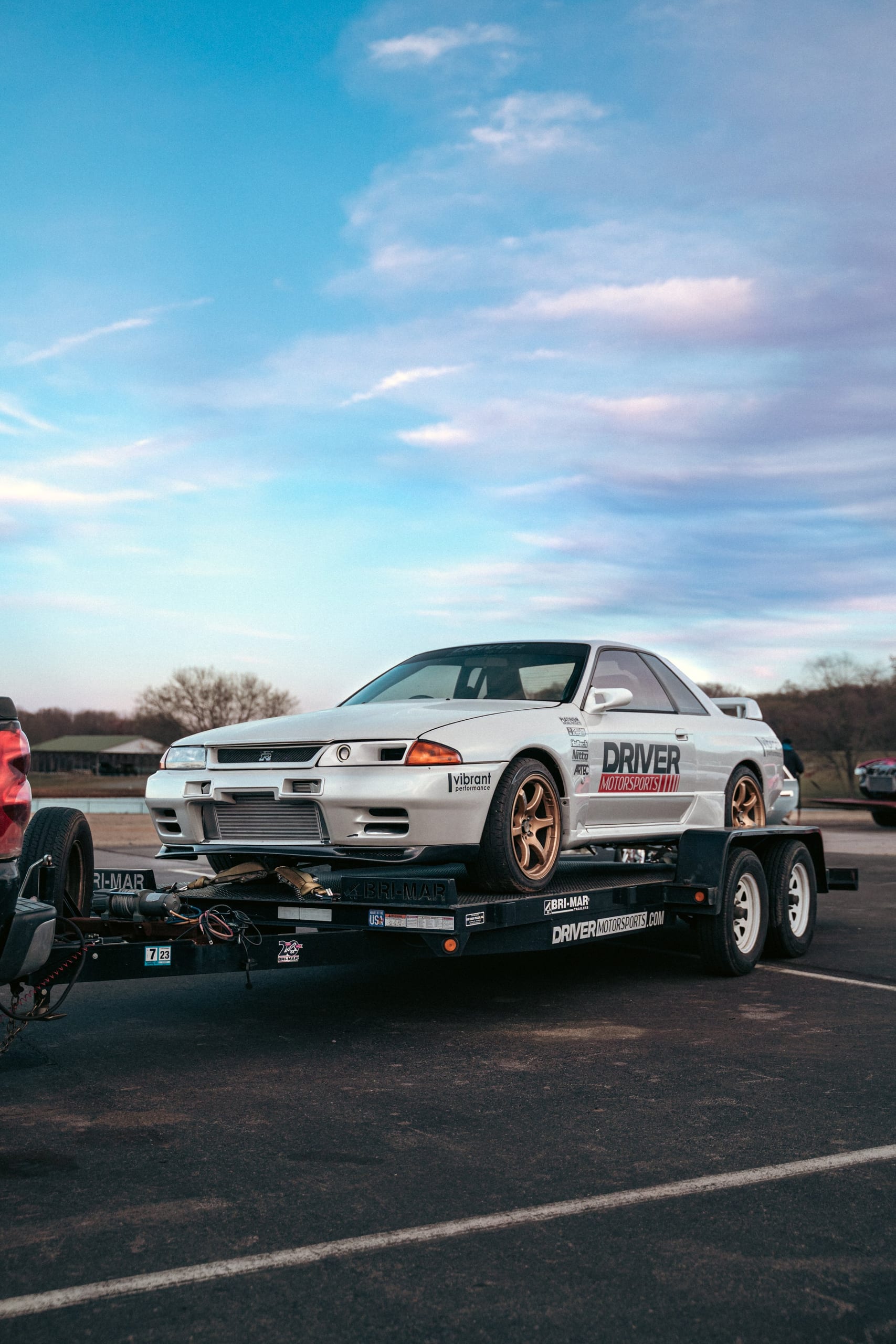 White Nissan Skyline GT-R loaded on a branded trailer ready for transport