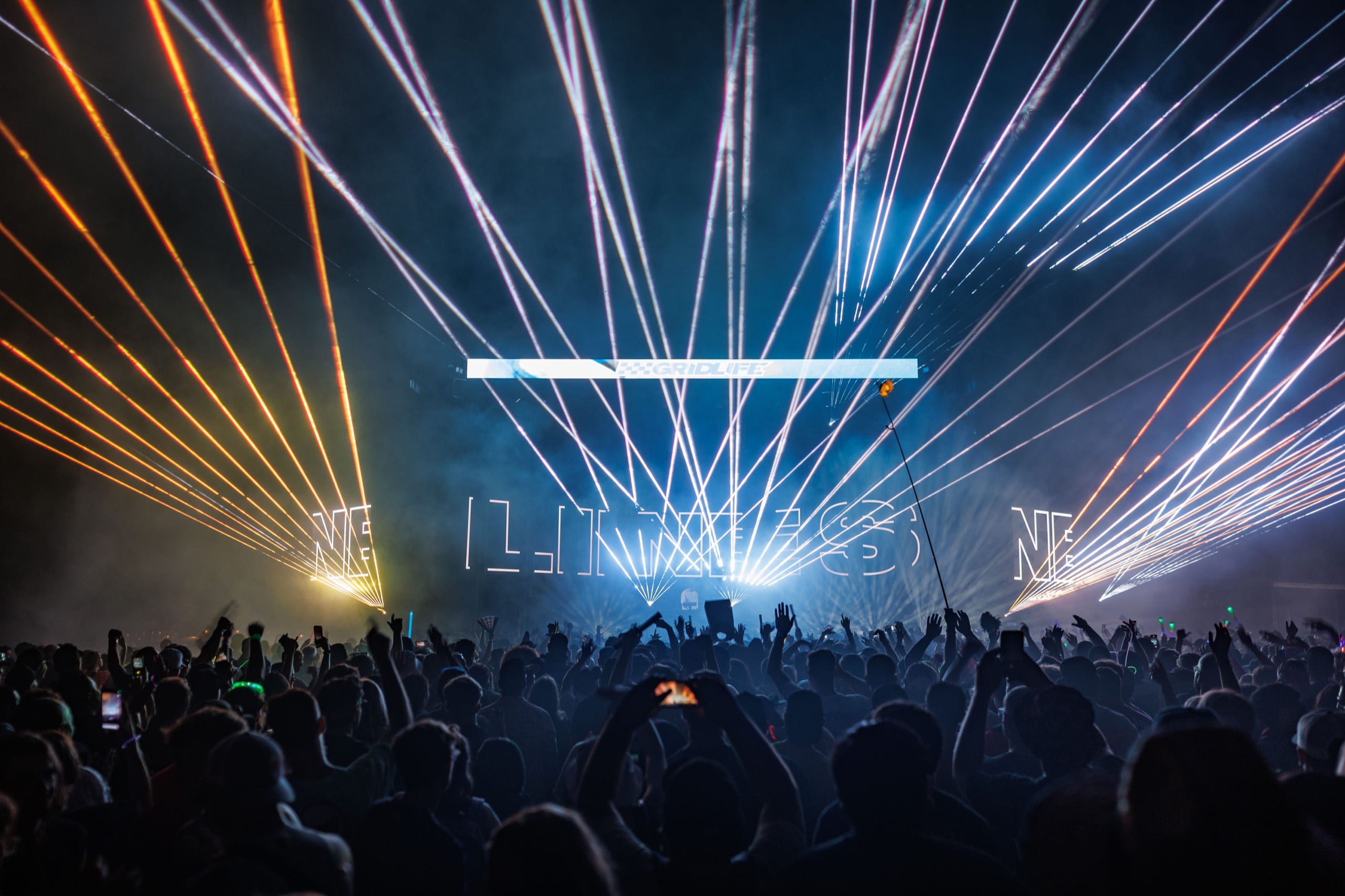 Laser-lit main stage and crowd during a GRIDLIFE night set
