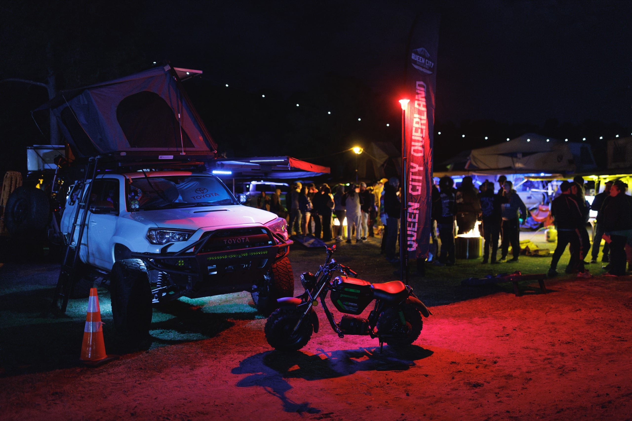 Overland rigs and rooftop tents glowing at the GRIDLIFE campground after dark