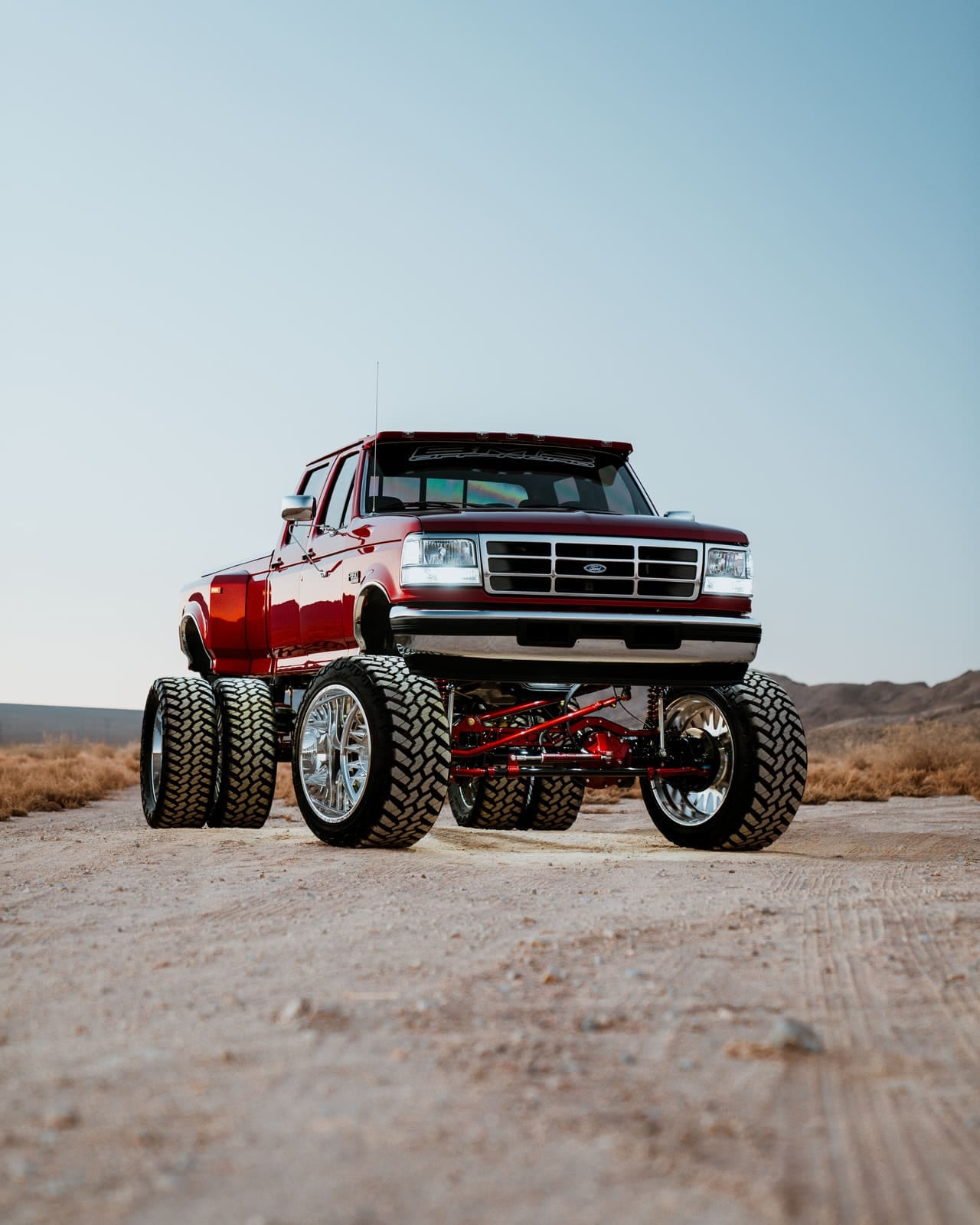 Red OBS Ford crew cab dually on RYD Motorsports suspension, shot low from the front in the desert