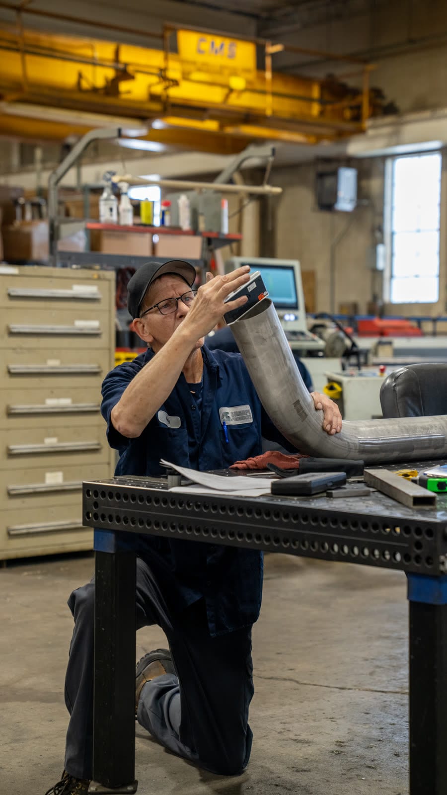Sharpe Products technician inspecting a bent tube section at a fixture table