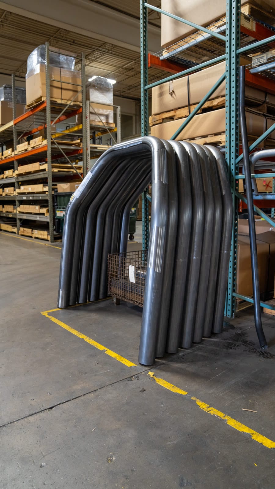 Large-radius bent tubes stacked on a cart in the Sharpe Products warehouse