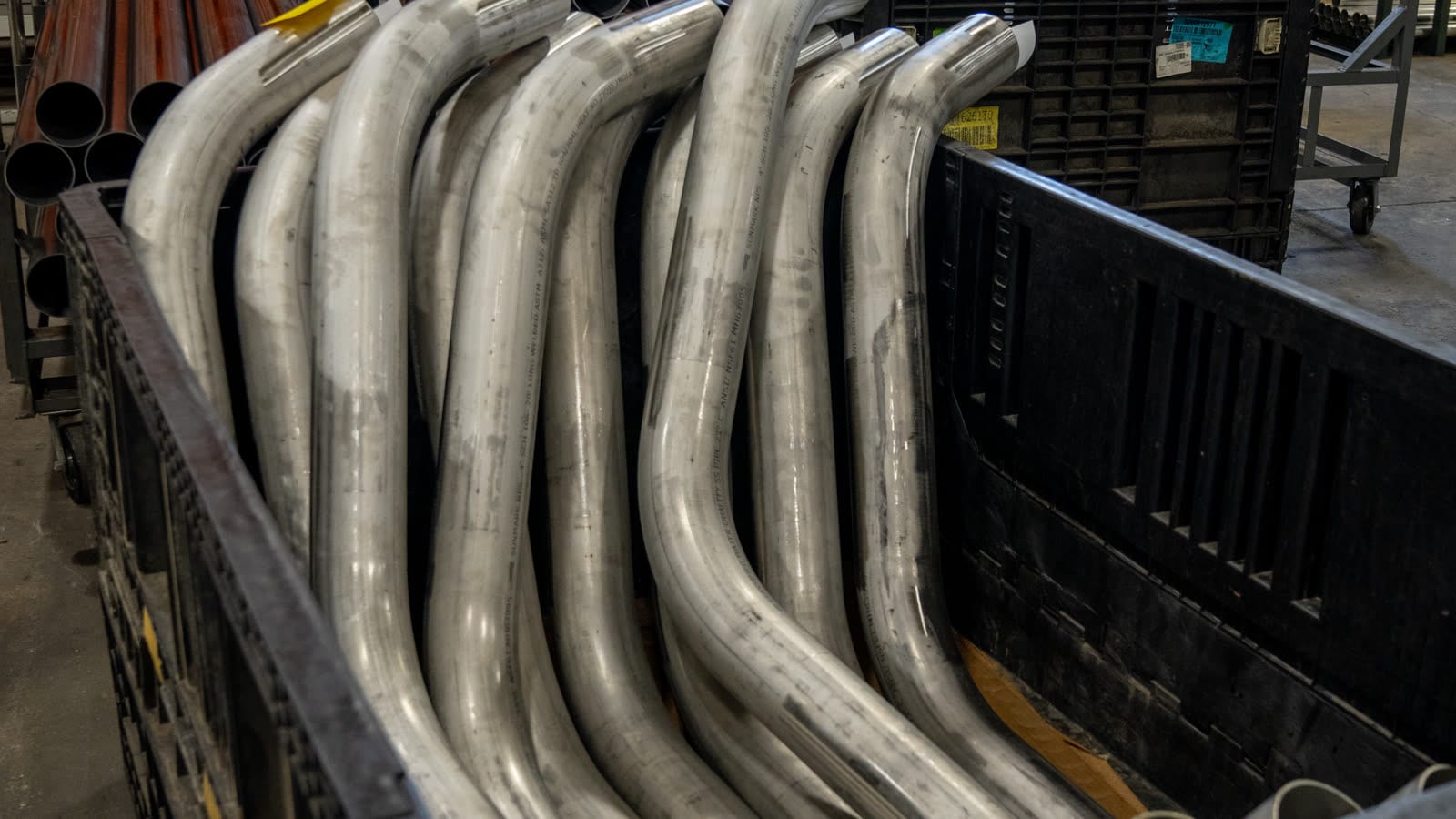 Freshly bent steel tubes stacked in a crate at the Sharpe Products facility