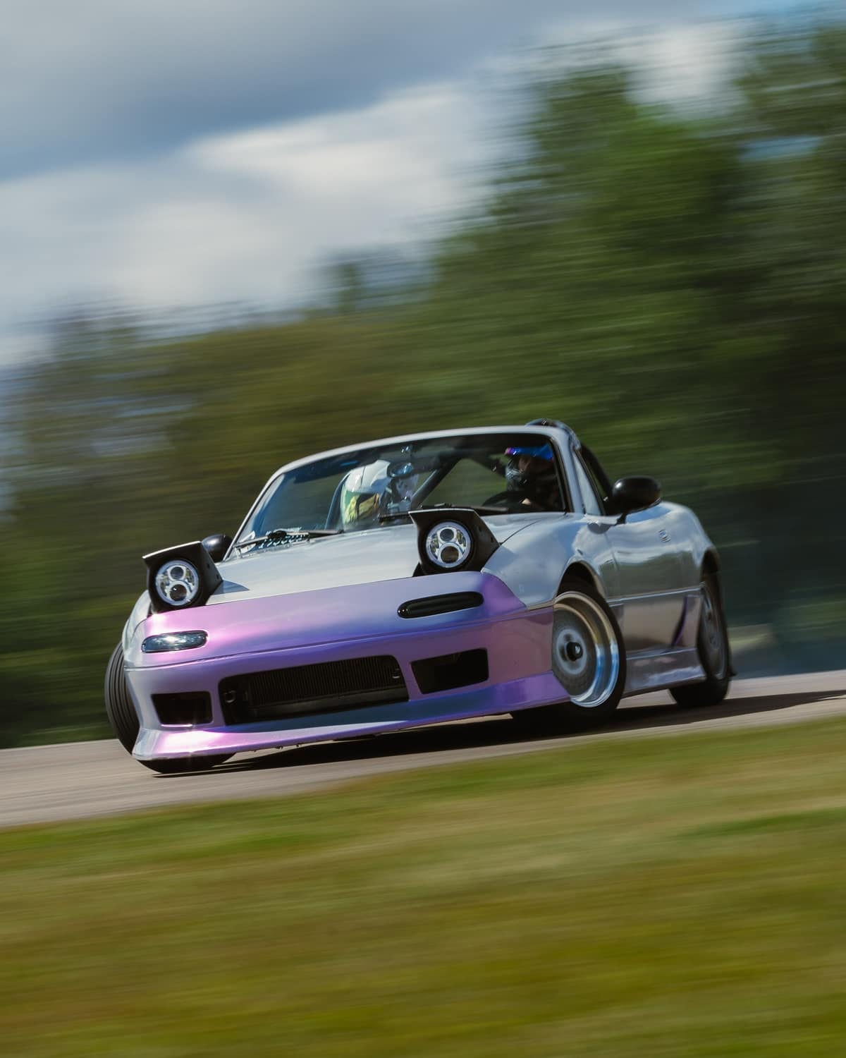 A widebody Mazda MX-5 at speed through a corner on a road course