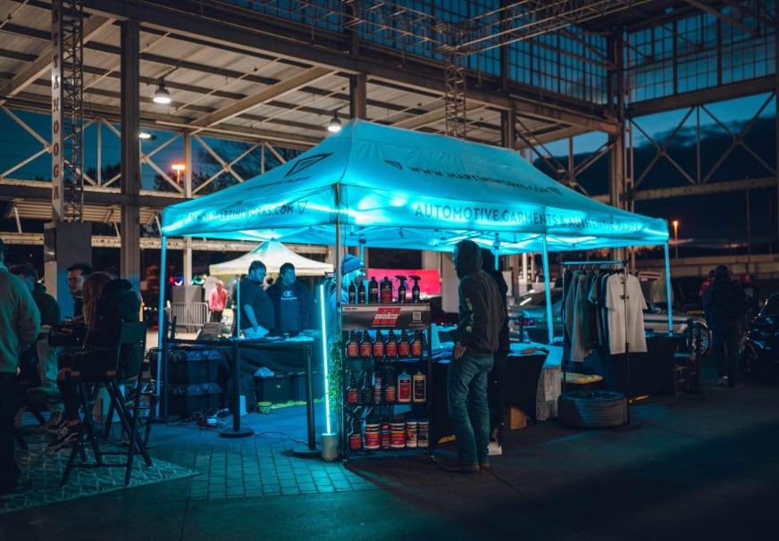 Illuminated vendor activation tent during an evening enthusiast event